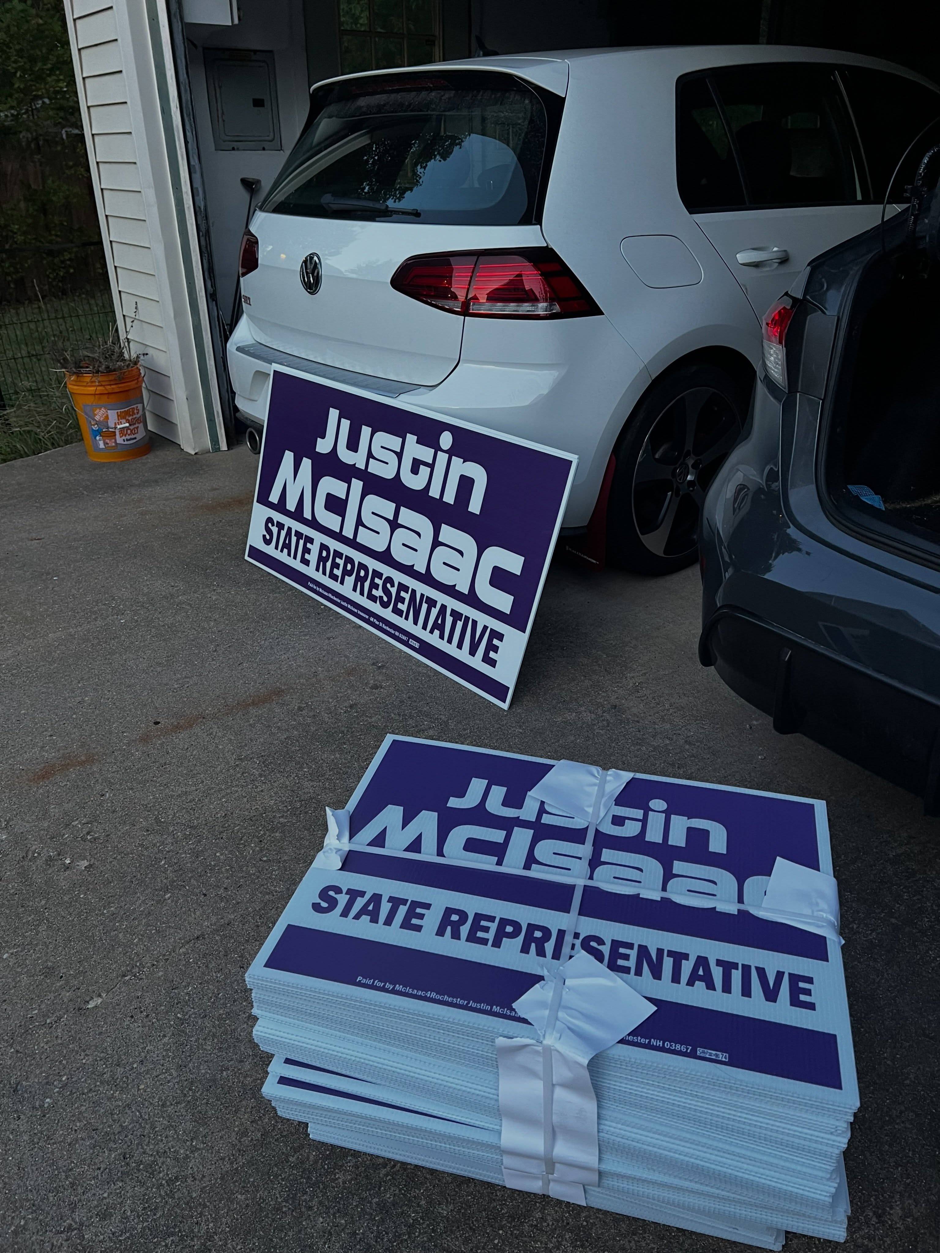 A stack of purple Justin McIsaac for State Representative yard signs